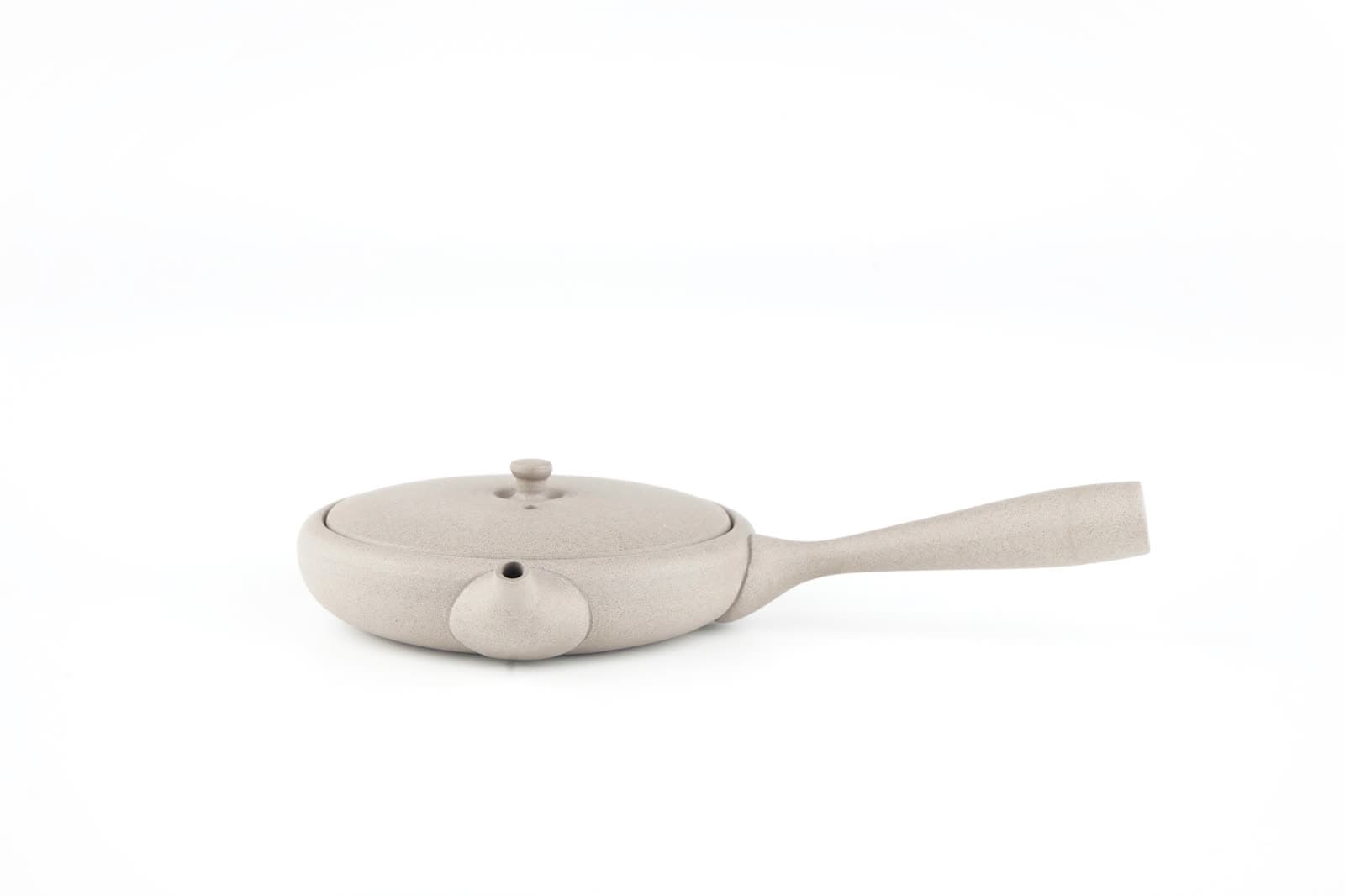 Kyusu plano de cerámica gris claro con mango lateral, sobre fondo blanco